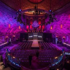 an empty auditorium with purple lighting and chandelier