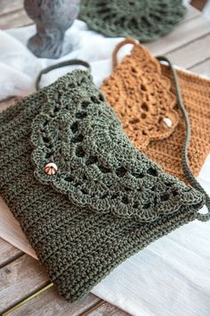 two crocheted bags sitting on top of a wooden table