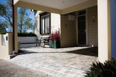 a patio area with chairs and tables in front of a house on a sunny day