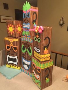 three tiki masks are stacked on top of each other in front of a table