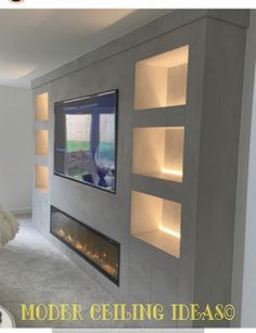 a living room with a large tv mounted on the wall and built - in shelving