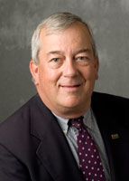 a man in a suit and tie smiling at the camera