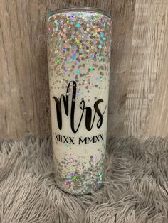 a white glitter tumbler with the words mr and mrs on it