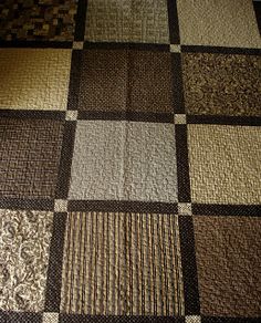 a brown and white checkered blanket on top of a bed