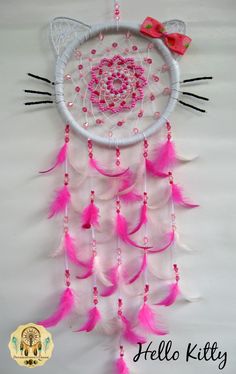 a pink and white cat dream catcher with feathers