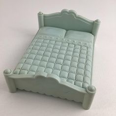 a small bed made out of plastic on a white surface with no headboard or foot board