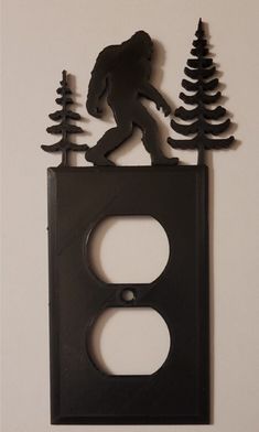 Bigfoot Believers? Hide Your Plugs in Style with This Sasquatch Recepticle Cover Is your boring old outlet cover bringing you down? Do you yearn for a touch of the wild in your home décor? Look no further than this enchanting sasquatch switch cover, featuring a silhouette of the legendary creature peeking out from behind some pine trees. Made with high-quality materials, this switch cover is built to last. It's the perfect way to add a touch of whimsy to any room in your house, and it's sure to be a conversation starter among friends and family. This sasquatch switch cover is also a great gift for any Bigfoot enthusiast or anyone who loves the beauty of the great outdoors. Order yours today and bring a bit of mystery to your home! Ask about other colors, or even our glow in the dark option Useful 3d Prints, Barn Style House Plans, Post Cap, Legendary Creature, Outlet Cover, Cabin Fever, Squad Goals, Barn Style, Pine Trees