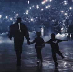 two children and an adult walking in front of a crowd