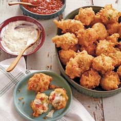 there are many different foods in bowls and plates on the table, including tater tots