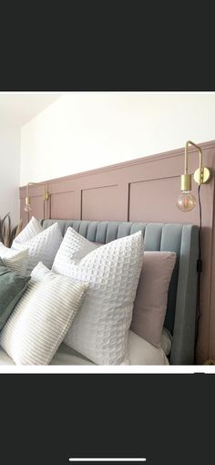 a bed with many pillows on top of it and a headboard in the background