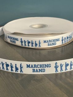 white and blue marching band ribbon on wooden table with black silhouettes in the background