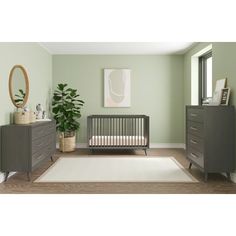 a baby's room with a crib, dressers and a potted plant