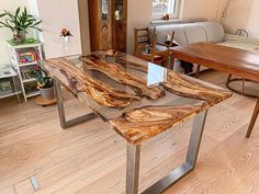 a wooden table sitting on top of a hard wood floor next to a living room