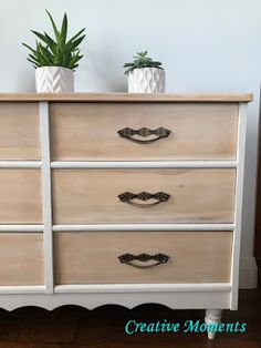 a white dresser with two potted plants on top and the words creative moments above it