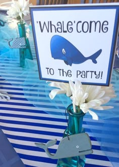 there is a sign that says whale come to the party with flowers in a vase