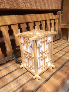 a wooden lantern sitting on top of a wooden bench