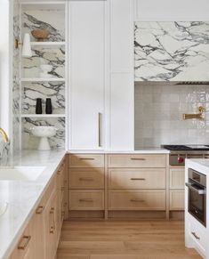 a kitchen with white marble counter tops and wooden cabinets, along with wood flooring