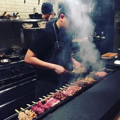 a man cooking food on top of a grill