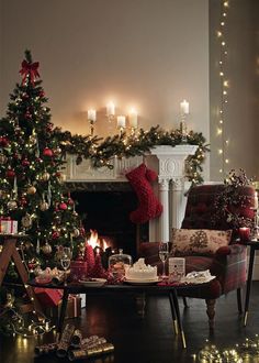 a living room decorated for christmas with candles and presents on the fireplace mantels