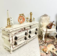 an old white dresser with many knobs on it