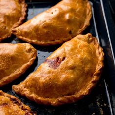 several baked pastries sitting on top of a baking pan