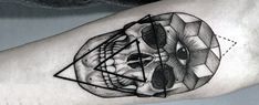 a black and white photo of a skull with geometric shapes on it's arm