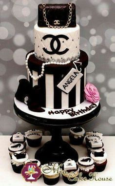 a chanel cake with cupcakes on the table