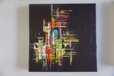 an abstract painting is hanging on the wall in front of a white wall with a black background