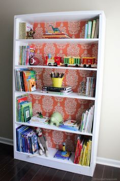 a bookshelf filled with lots of books on top of a hard wood floor