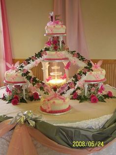 a wedding cake with pink flowers and candles