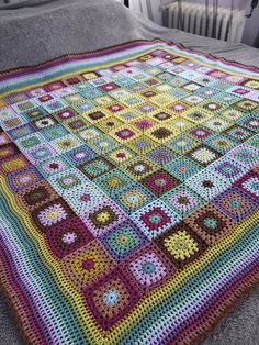 a crocheted blanket is laying on a bed