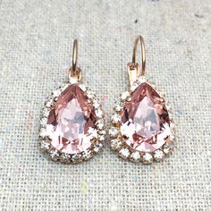 "Heatherly Designs™ dangling earrings featuring genuine Swarovski® crystals in blush pink surrounded by a delicate pave halo of smaller Swarovski® crystals in crystal faux diamond. The earrings are solid brass that has been plated. ●Nickel free ●Size (L x W): 1\" x .5\" or 28 x 13mm ●Swarovski® crystal color name(s): Vintage Rose + Crystal ●Arrives in our signature Heatherly gift box. Handmade with ❤️ by Heather ● ● ● ● ● ● ● ● ● ● ● ● ● ● ● ● ● ● ● ● ● ● ● ● ● ● ● ● →Quantity Discounts listed b Blush Pink Earrings, Morganite Earrings, Bridal Earrings Studs, Blush Earrings, Pear Halo, Stone Drop Earrings, Crystal Teardrop Earrings, Bridal Earrings Drop, Gold Bridal Earrings