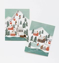 two christmas cards with houses and trees on them