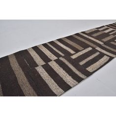 a brown and white striped rug on a white floor with no one in the photo