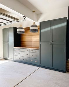 an empty room with blue cabinets and hanging lights