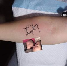 a woman with a tattoo on her arm holding a baby