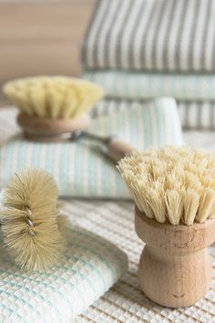 two shaving brushes sitting on top of towels