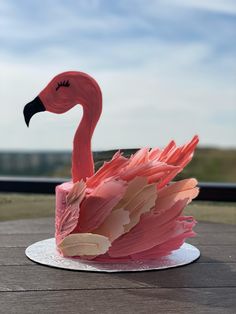 a pink flamingo cake sitting on top of a white plate