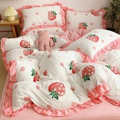 a bed with pink and white sheets, pillows and a teddy bear