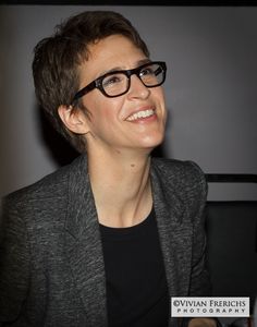 a woman wearing glasses sitting at a table