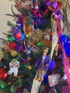 a christmas tree with toys and decorations on it's branches, including a toy man