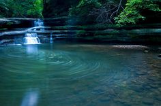 a small waterfall in the middle of a forest