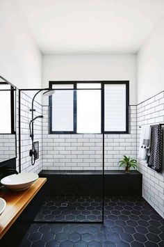 black and white bathroom with hexagonal tile flooring, double sinks, and shower