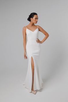 a woman wearing a white gown with a slit in the side