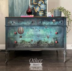 an old dresser has hot air balloons painted on the front and sides, along with other decorative items