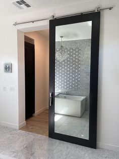 a bathroom with a large mirror on the wall and a bathtub in the corner