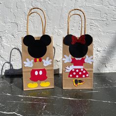 two brown bags with mickey and minnie mouse designs are sitting on a table next to each other