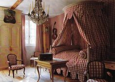 an old fashioned bedroom with red and white checkered bedspread on the bed