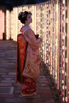 a woman standing next to a wall covered in lights