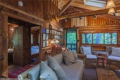 a living room filled with furniture and wooden walls